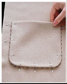 someone is stitching the stitches on a piece of fabric to make a square shape