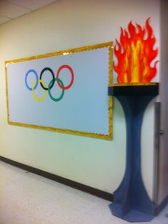 the olympic logo is on display next to a fire hydrant in an office hallway