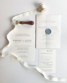 the wedding stationery is laid out on top of each other, including a wax seal and ribbon