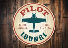 a sign that says pilot lounge on the side of a wooden wall with an airplane