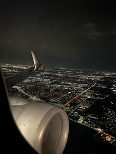 an airplane wing flying over a city at night