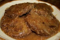 some meat and gravy on a white plate