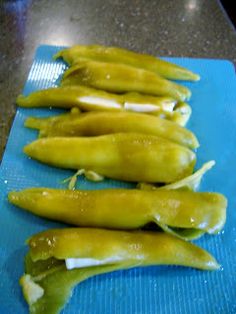 green peppers are lined up on a blue cutting board