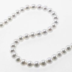 a single strand of white pearls on a white background