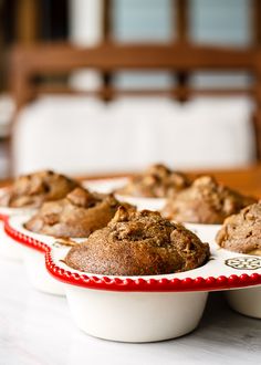 some muffins are sitting on a red and white plate next to each other