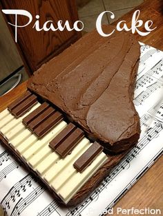 a chocolate piano cake sitting on top of sheet music