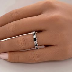 a woman's hand with a black and white diamond ring