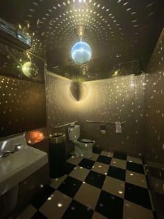 a bathroom with a black and white checkered floor, ceiling light and bathtub