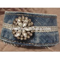 a blue jean cuff with a crystal flower on it