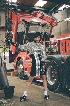 a woman standing in front of a semi truck