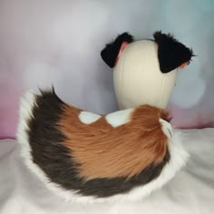 a stuffed animal that is laying down on a bed with its head turned to the side