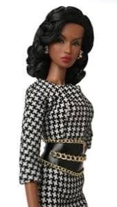 a barbie doll wearing a black and white dress with gold chains on her belt,