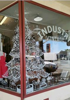 a christmas tree in the window of an antique store