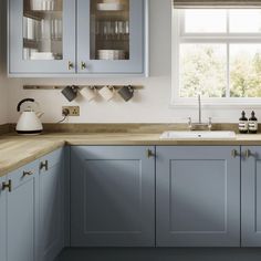 a kitchen with blue cabinets and wooden counter tops