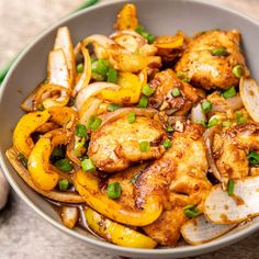 a bowl filled with chicken and vegetables on top of a table