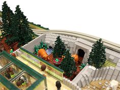 a lego model of a train station with lots of trees and animals in the area