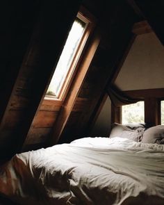 an attic bedroom with slanted ceilings and white bedding