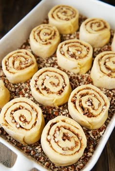 several cinnamon rolls in a white baking dish