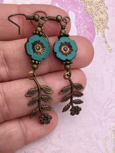 Flowers, flowers, and more flowers! The beautiful teal flowers are Czech glass beads. I paired them with high quality Vintaj charms, which are solid brass and American made using an eco friendly process. The effect of combining natural brass and Czech glass beads is so pretty to me. I love the elegant, vintage look it creates. The hooks on these earrings are antique brass and are nickel free. All of my earrings come on a hand stamped earring card and are lovingly wrapped in colorful tissue and p Nickel-free Czech Glass Flower Earrings, Vintage Turquoise Flower Earrings, Vintage Turquoise Dangle Flower Earrings, Bohemian Brass Flower Earrings, Turquoise Nickel Free Flower Earrings, Bohemian Turquoise Flower Earrings Nickel Free, Vintage Flower Charm Dangle Earrings, Czech Glass Flower Earrings With Flower Charm, Bohemian Czech Glass Flower Earrings