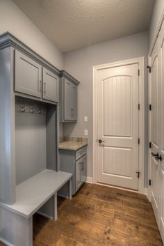 an empty entryway with gray cabinets and white doors on both sides is shown in this photo