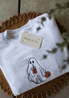 Get ready for the spooky season with our Embroidered Iced Coffee Ghost Crewneck! This cute and cozy sweatshirt features an adorable ghost enjoying an iced coffee, perfect for Halloween and fall fashion lovers. Why You'll Love It: Unique Design: Custom embroidered ghost with iced coffee, exclusively designed for this crewneck!  High-Quality Material: Made from soft, durable fabric to keep you comfortable all autumn long!  Perfect for Fall: Ideal for Halloween parties, pumpkin patch visits, or jus Fall Sweater Designs, Halloween Embroidery Designs Sweater, Halloween Clothes Aesthetic, Fall Embroidered Sweatshirts, Embroidered Clothes Ideas, Sweatshirts Ideas, Autumn Sweatshirts, Ghost With Coffee, Ghost Crewneck