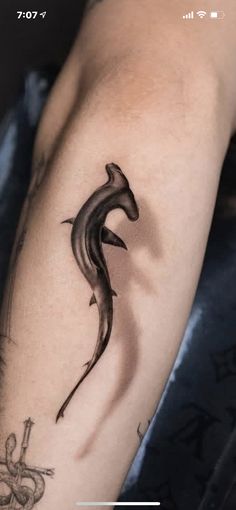 a black and white photo of a lizard tattoo on the right arm, with an arrow in the middle