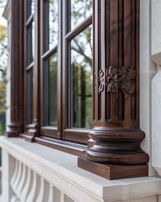 an ornate wooden window frame on the outside of a building with glass doors and windows