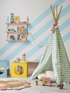 a child's playroom with a teepee tent and toys on the floor