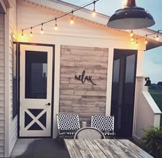 the front porch is decorated with lights and chairs