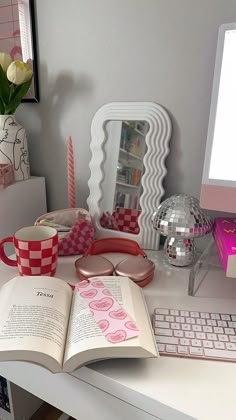 an open book sitting on top of a white desk next to a keyboard and mouse