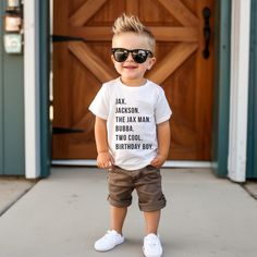 a young boy wearing sunglasses standing in front of a door with his birthday shirt on