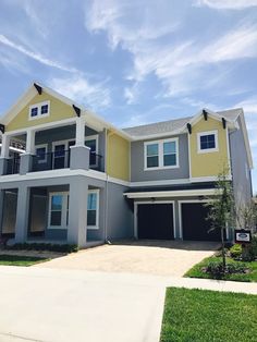 a two story house with yellow and gray paint