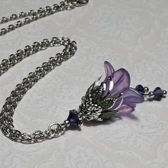 VIOLET SILVER FLOWER PENDANT  ▪️▪️▪️▪️▪️▪️▪️️▪️▪️▪️▪️▪️▪️ This pretty vintage inspired violet purple pendant is made with a super cute Lucite fairy flower which has been hand painted with an iridescent finish. It has Swarovski crystals in beautiful deep purple added for sparkle when it moves and is finished with ornate floral bead caps and either 16'' or 18'' chain that can be chosen from the drop down menu. Beautifully light weight, perfect for special occasions, festivals and bridesmaids yet c Fairy Jewelry Purple, Luxury Purple Flower Pendant Jewelry, Luxury Purple Flower Pendant Necklace, Affordable Purple Flower-shaped Jewelry, Violet Pendant Necklace, Purple Flower Accessories, Purple Cross Necklace, Fairycore Necklace Purple, Purple Crystal Necklace