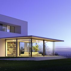 a modern house is lit up at night