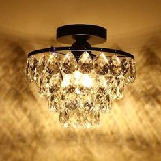 a chandelier hanging from the ceiling in a room with light shining on it