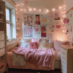 a bedroom with lights strung above the bed and pictures on the wall behind the bed