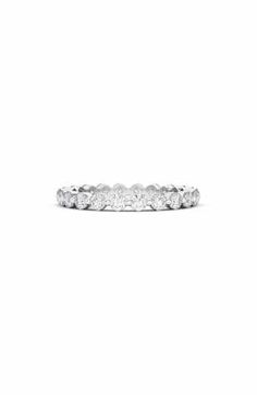 a white gold wedding band with five round diamonds on the top and bottom half of it