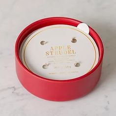 an apple strudel in a red box on a marble counter top with the lid open