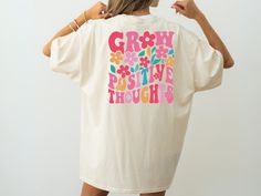 Spread positivity and good vibes with this cheerful "Grow Positive Thoughts" shirt! Featuring a vibrant floral design and a motivational message, this tee is perfect for those who love to express their positive mindset through fashion. Whether you're enjoying a sunny day, attending a casual get-together, or simply want to boost your mood, this colorful shirt is sure to inspire. Our Products Our adult apparel uses premium Gildan brand t-shirts, sweatshirts, and hoodies. These garments are perfect for casual wear, offering both durability and comfort. All designs are printed using DTF (Direct to Film) printing technology, ensuring vibrant colors and durability. These garments are crafted to provide comfort and style, making them suitable for any occasion. Whether you're looking for casual ev Positive Graphic Tees, Positive Tee Shirts, Motivational Cheerful Shirts, Positive Message T Shirts, Positive Message Shirts, Duck Hunting Shirts, Camo Tee, Motivational Messages, Hunting Shirts