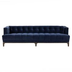 a blue velvet sofa with wooden legs