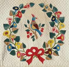 a quilted wreath with flowers and birds on it