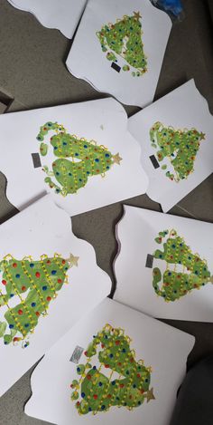 several pieces of paper cut out to look like christmas trees