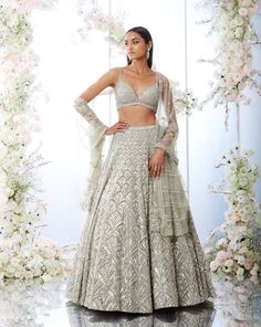 This lehenga set features platinum cut sequin and crystal embellishment in a cascade motif pattern. The ensemble is paired with a criss-cross back and fully embroidered net dupatta.From Seema Gujral's Tuscan Summer collection. DELIVERY TIMEPlease allow 8-12 weeks for your outfit to arrive. FABRIC DETAILSNet Professional cleaning only. Crystal Lehenga, Pearl Lehenga, Grey Lehenga, Seema Gujral, Sangeet Outfit, Desi Outfits, Indian Outfits Lehenga, Net Lehenga, Red Lehenga