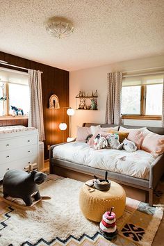 a living room filled with furniture and lots of pillows on top of a white rug