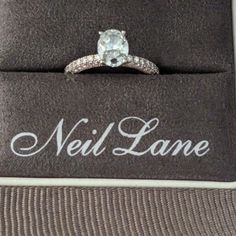 an engagement ring is sitting on top of a black and white box with the name neil lane written on it