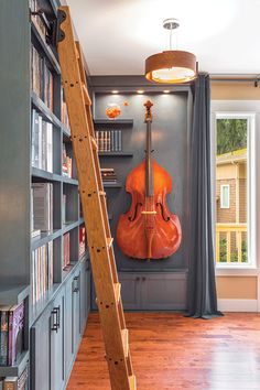 a room that has a ladder in the middle of it and a violin on the wall