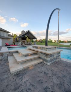 an outdoor swimming pool with steps leading up to it and a fire pit in the background