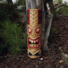 a tiki statue sitting next to a tree