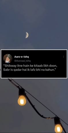 the moon is shining in the sky above some street lights with an ad on it