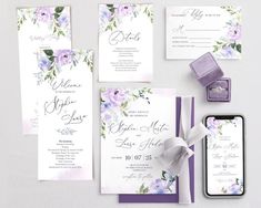 wedding stationery with purple and lavender flowers on the front, white envelopes, and matching rings